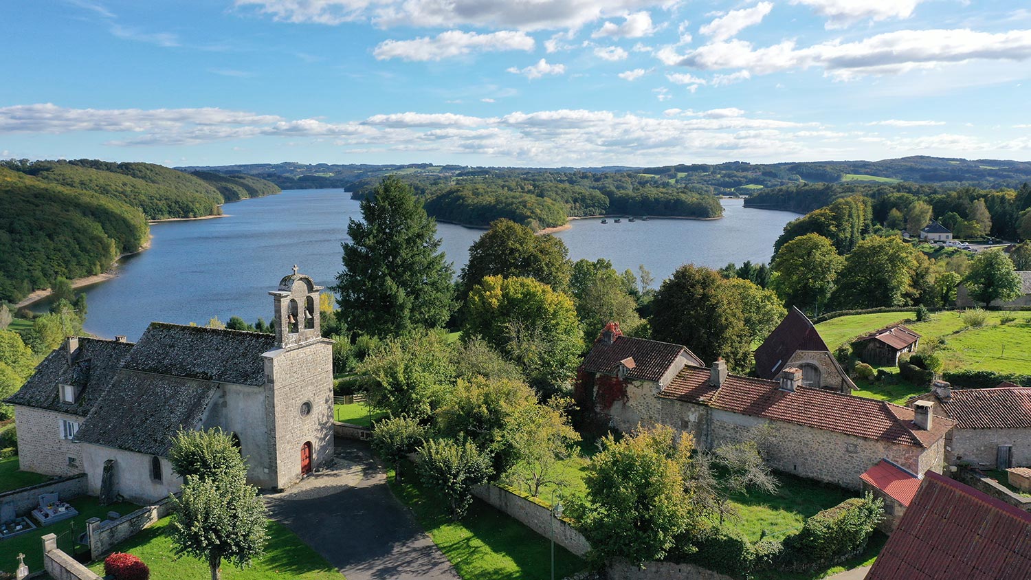 Vue aérienne de l'église de Saint Etienne Cantalès et son lac de barrage
