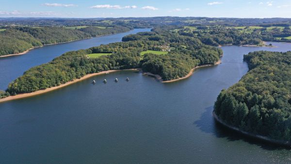 Vue d'ensemble du Lac de barrage de Saint-Etienne-Cantalès et ses chalets flottants dans le Cantal 
